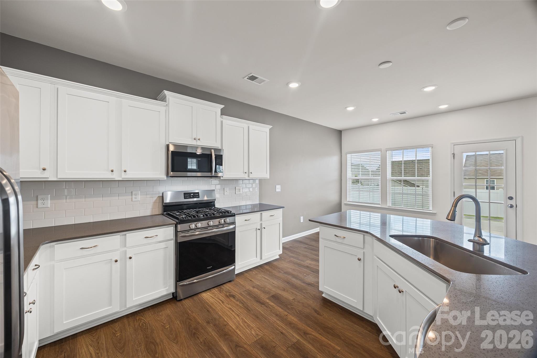 5775 Soft Shell Drive Lancaster, SC 29720 - Photo 16 of 40 a kitchen with granite countertop white cabinets and stainless steel appliances