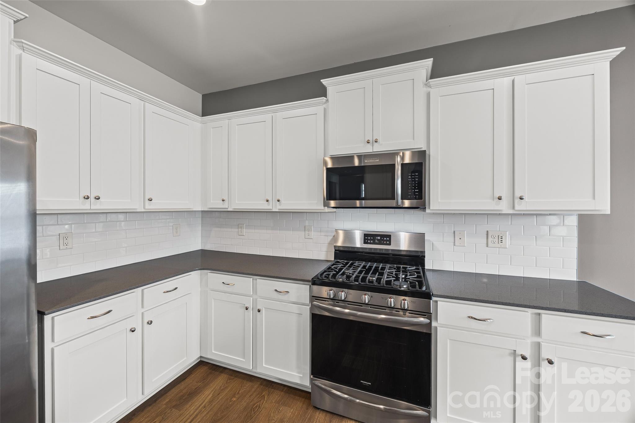 5775 Soft Shell Drive Lancaster, SC 29720 - Photo 17 of 40 a kitchen with white cabinets and stainless steel appliances