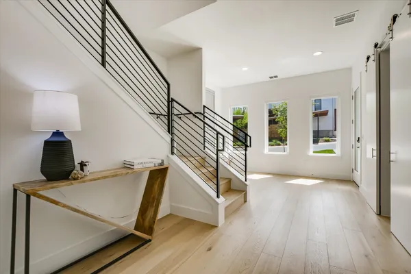 a view of entryway and hall with wooden floor