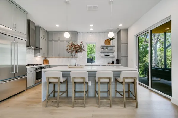 a kitchen with stainless steel appliances kitchen island granite countertop a stove a sink and a refrigerator
