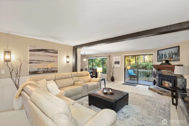 a living room with furniture a fireplace a large window and a flat screen tv