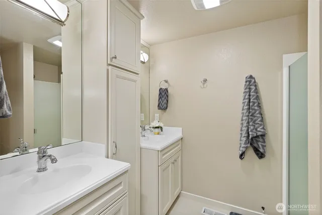 a bathroom with a sink vanity and mirror