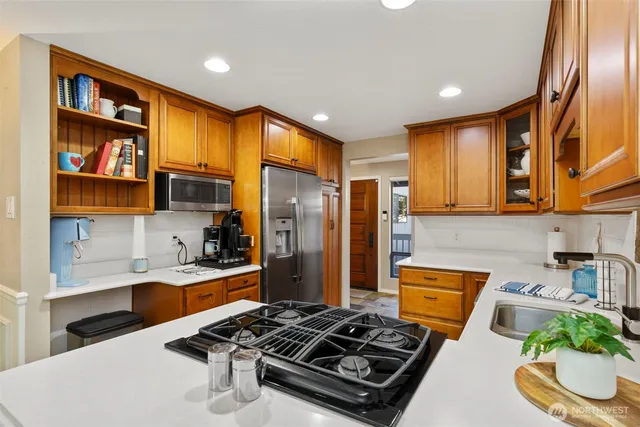 a kitchen with stainless steel appliances granite countertop a stove refrigerator and cabinets