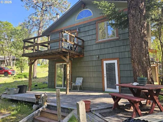 a view of a dinning tables and chairs in a patio in front of a house