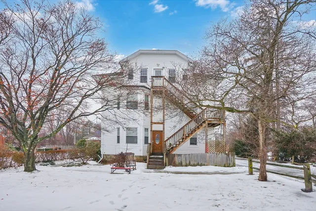 a front view of a building with large trees