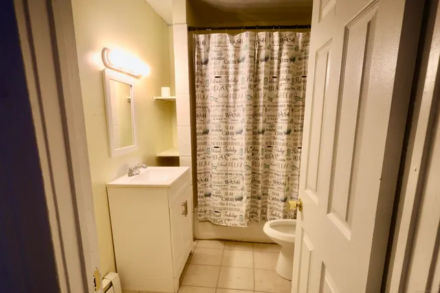 a bathroom with a shower curtain and a sink