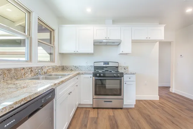 a kitchen with stainless steel appliances granite countertop a stove and a sink
