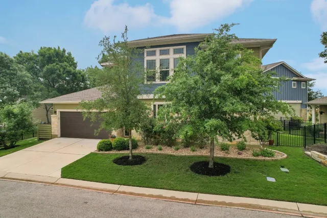 a front view of a house with a yard and trees