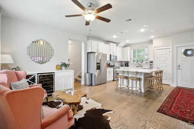 a living room with furniture a chandelier and kitchen view