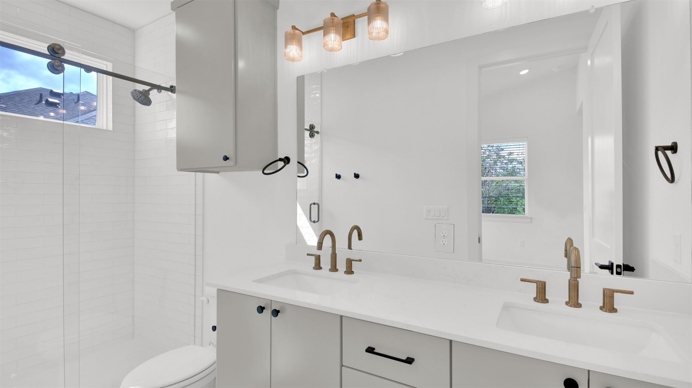 7208 Providence Avenue, Unit 1 Austin, TX 78752 - Photo 17 of 26 This bathroom features a double vanity with light-colored countertops, bronze-toned fixtures, and a large mirror