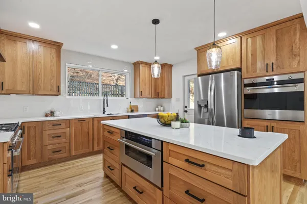 a kitchen with a sink a counter space appliances and cabinets