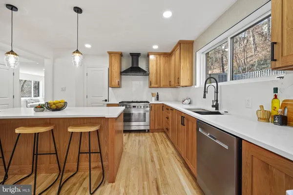 a kitchen with a stove a sink a refrigerator and windows