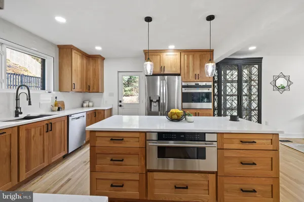a dining room with furniture a potted plant and a kitchen view