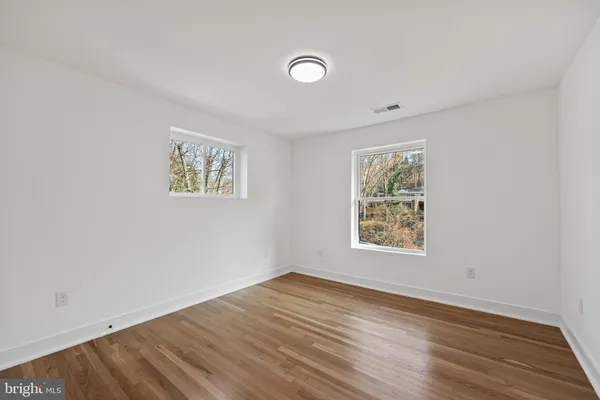 a bedroom with a bed a mirror and a potted plant