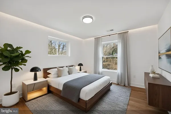 a bedroom with a bed a mirror and night stand