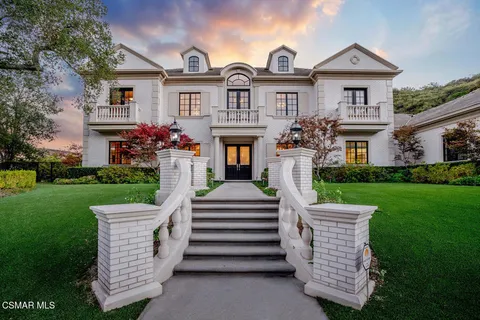 a front view of a house with a garden and plants
