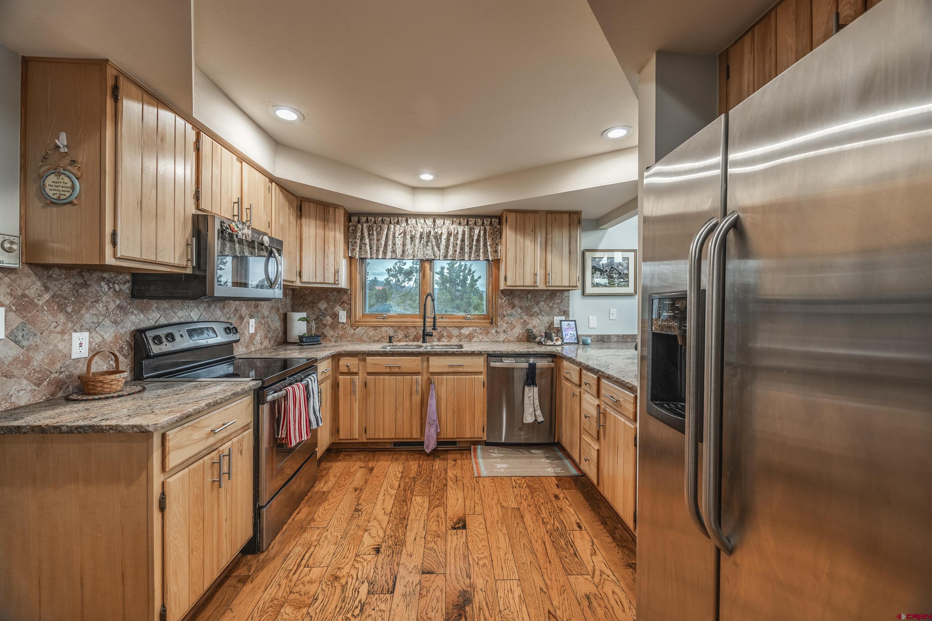 21186 Uintah Road Cedaredge, CO 81413 - Photo 18 of 45 a large kitchen with stainless steel appliances granite countertop a stove a sink dishwasher and a refrigerator
