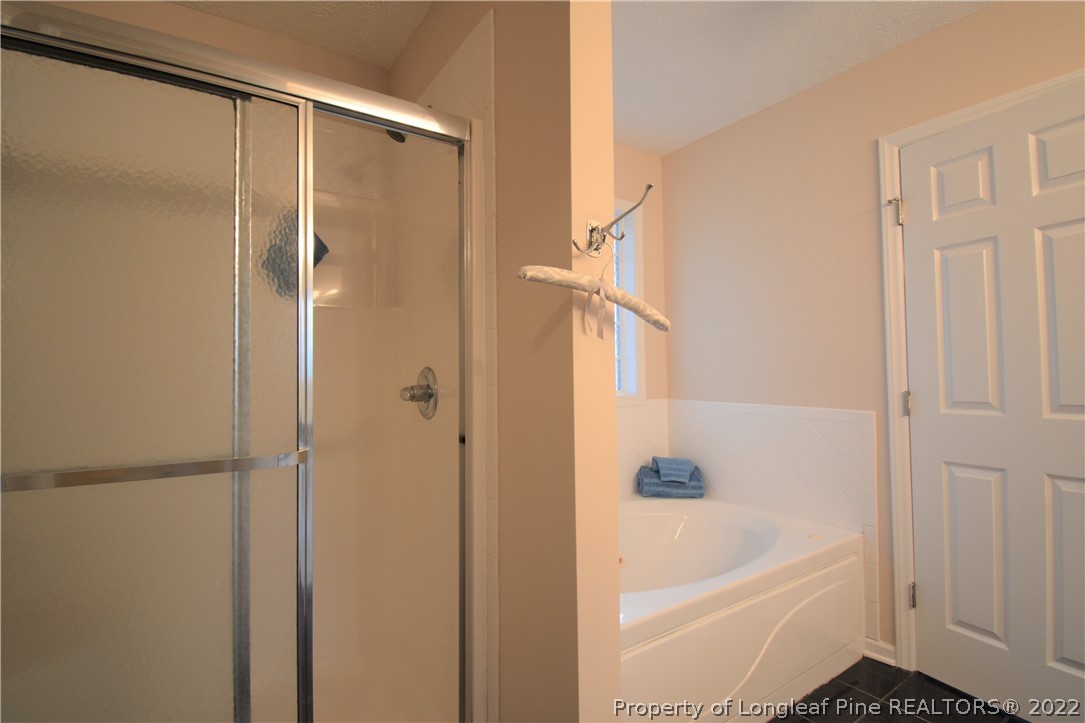 4308 Rocinta Court Hope Mills, NC 28348 - Photo 13 of 23 a bathroom with a bathtub a toilet and a shower