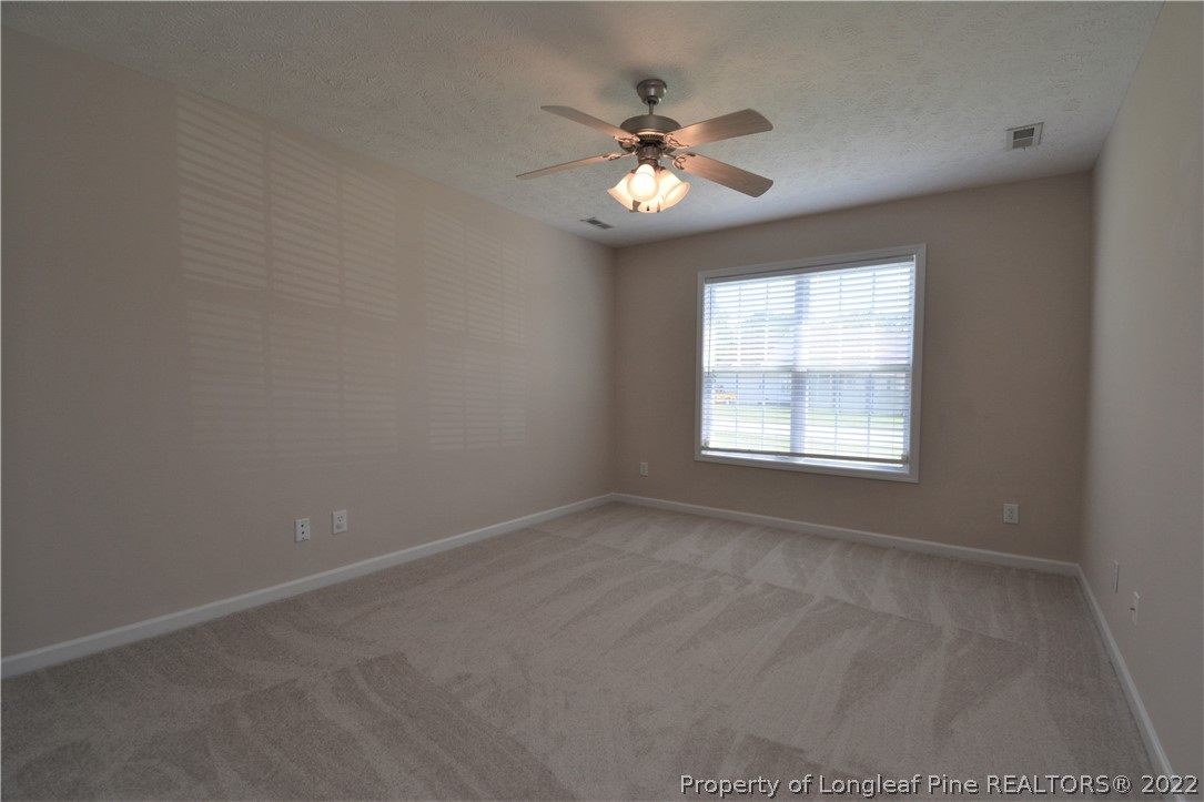 4308 Rocinta Court Hope Mills, NC 28348 - Photo 16 of 23 en empty room with windows and chandelier fan