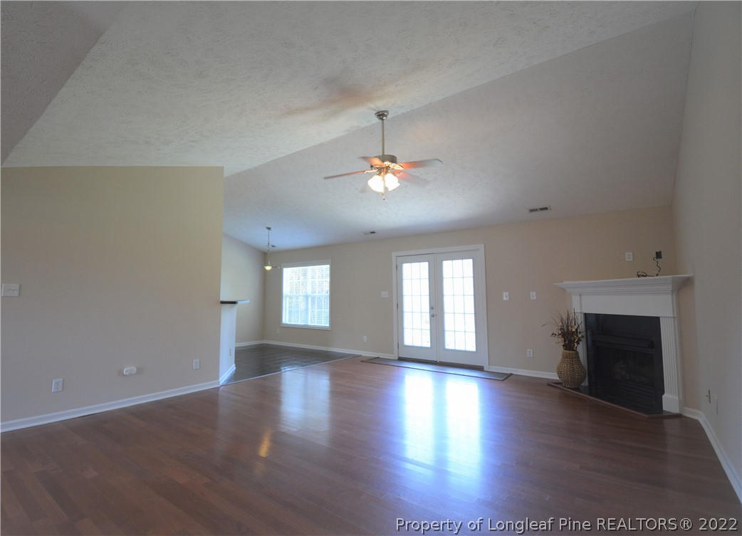 4308 Rocinta Court Hope Mills, NC 28348 - Photo 3 of 23 an empty room with wooden floor fireplace and windows