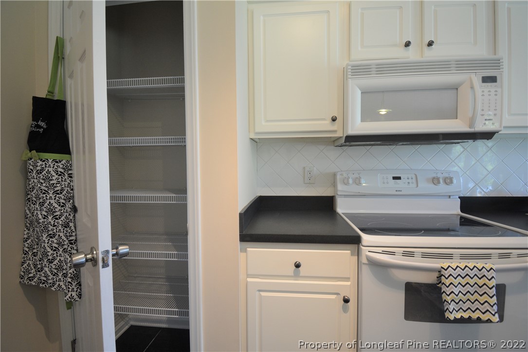 4308 Rocinta Court Hope Mills, NC 28348 - Photo 5 of 23 a kitchen with a stove and white cabinets