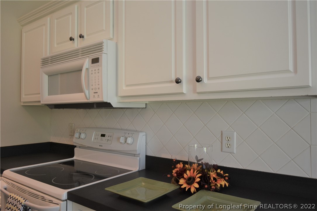 4308 Rocinta Court Hope Mills, NC 28348 - Photo 7 of 23 a kitchen with white cabinets and white appliances