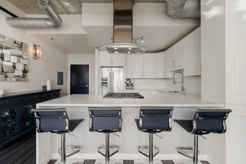 a kitchen with cabinets a counter and chairs