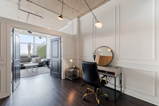 a view of a workspace with furniture and wooden floor