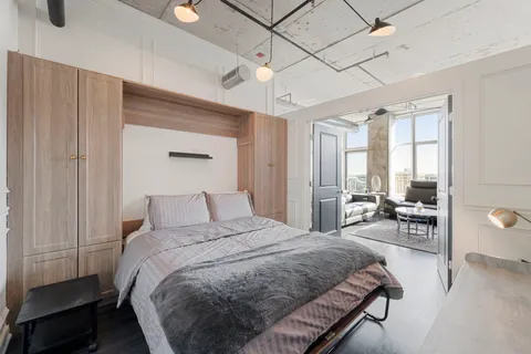 a bedroom with a bed couch and a window