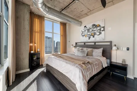 a bedroom with a large bed and a chandelier