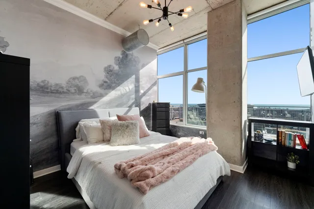 a bedroom with a large bed and a chandelier