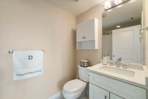 a bathroom with a toilet sink vanity and mirror