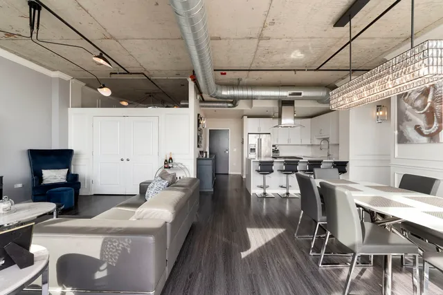a living room with stainless steel appliances furniture stove rug and a kitchen view