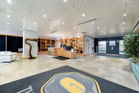 a living room with stainless steel appliances lots of white furniture