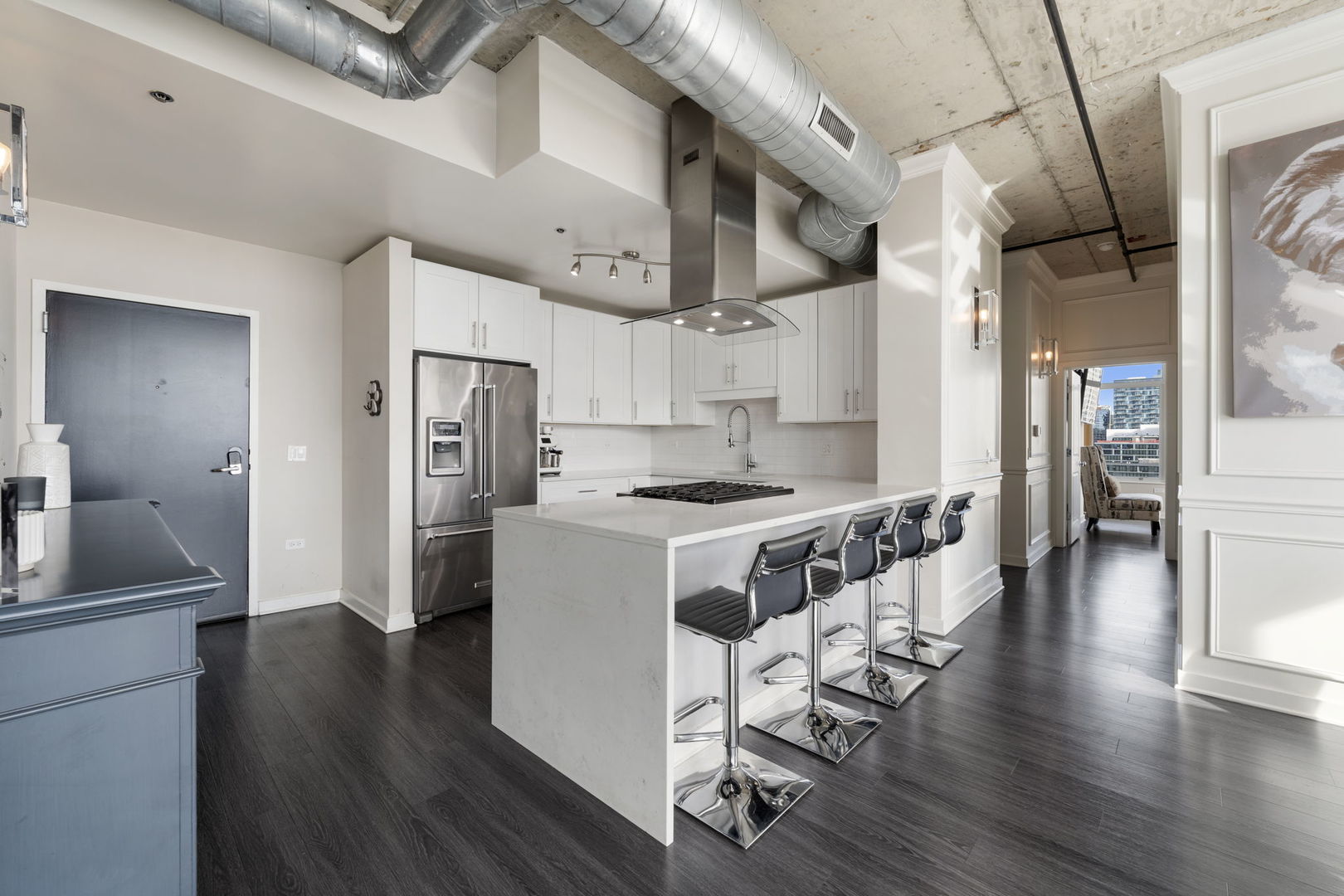 50 East 16th Street, Unit 1405 Chicago, IL 60616 - Photo 7 of 36 a kitchen with stainless steel appliances granite countertop a refrigerator a sink dishwasher a stove and white cabinets with wooden floor