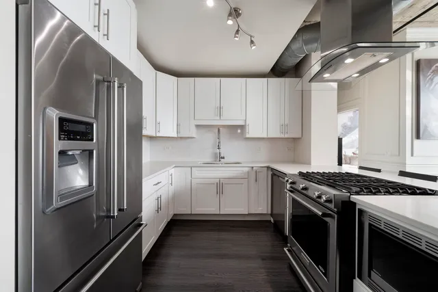 a kitchen with stainless steel appliances granite countertop a stove and a refrigerator