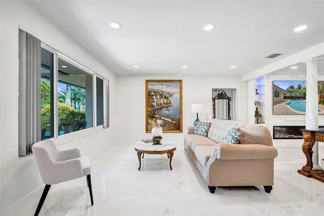 a living room with furniture large window and flat screen tv