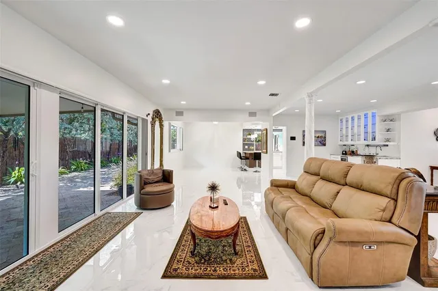 a view of a dining room and livingroom with furniture wooden floor a chandelier