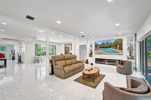 a kitchen with stainless steel appliances granite countertop a refrigerator a sink a stove and white cabinets