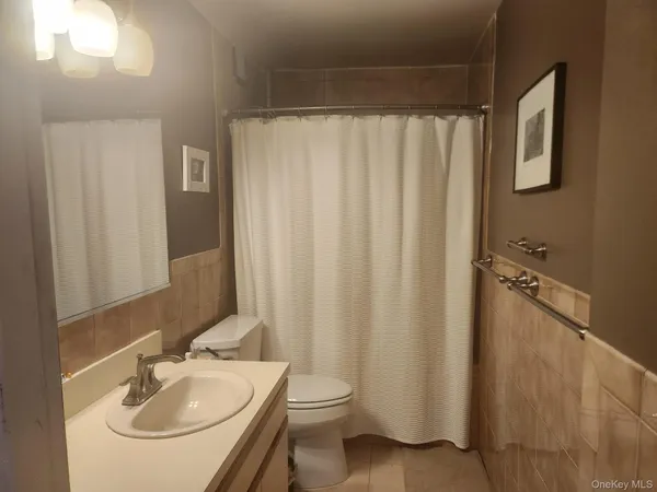 a bathroom with a sink a toilet and shower curtain