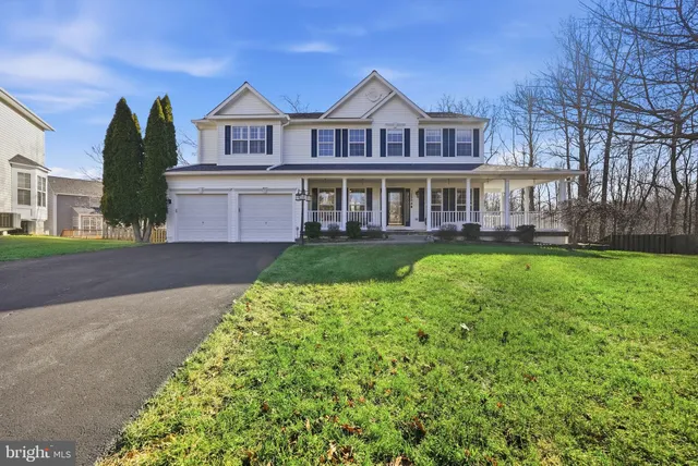 a front view of a house with a yard and potted plants
