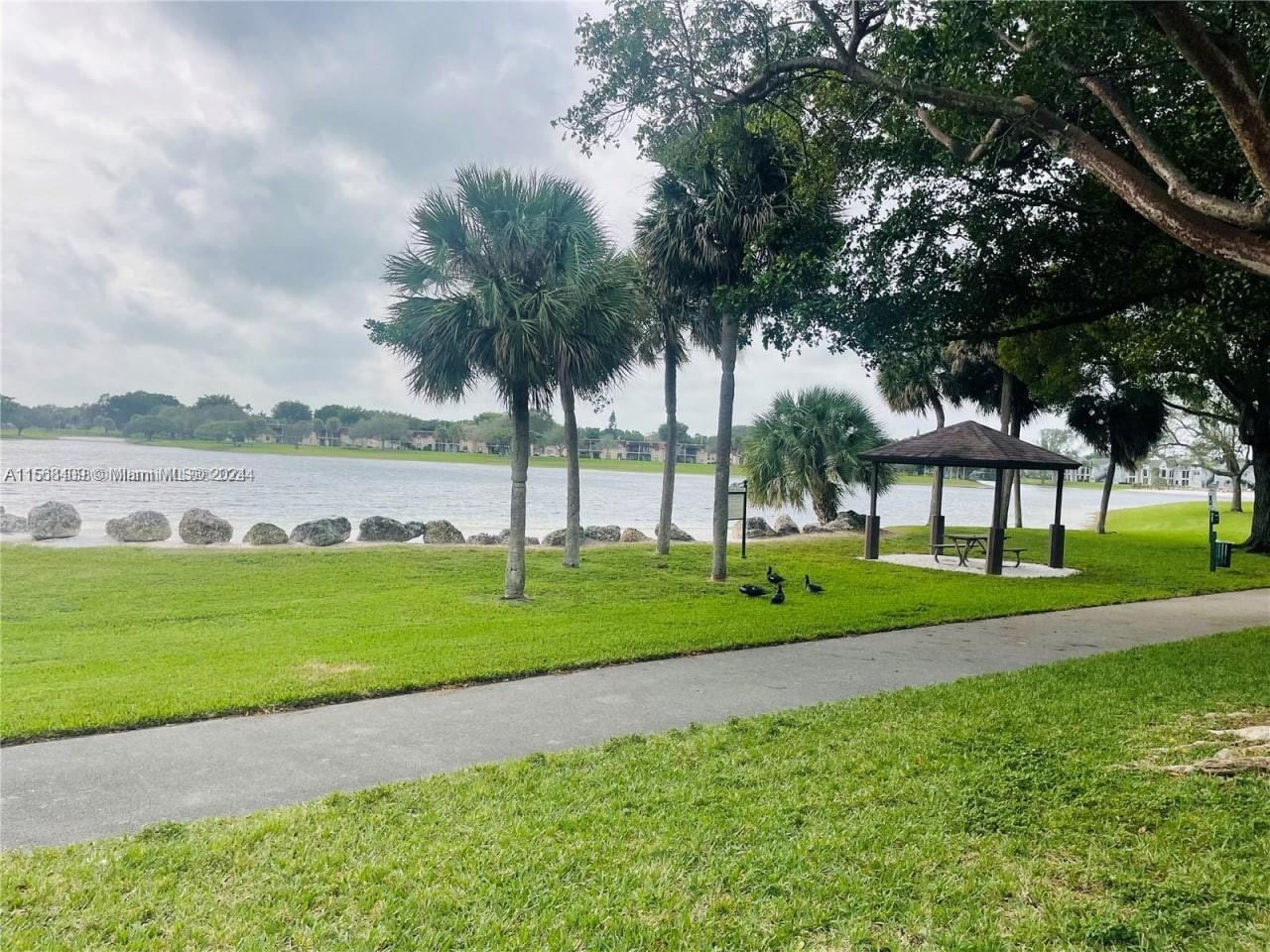 9701 Hammocks Boulevard, Unit 108A Miami, FL 33196 - Photo 6 of 8 a view of a park and trees with wooden fence