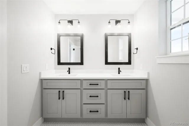 a bathroom with double sink and a mirror