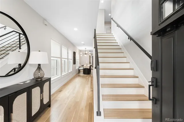a view of a hallway with wooden floor and staircase
