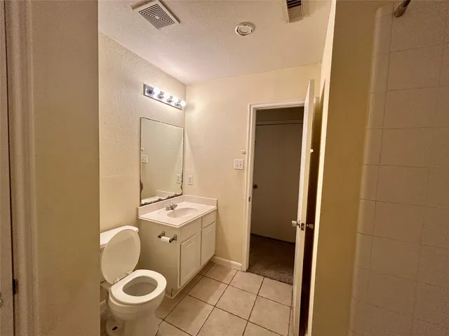 a bathroom with a sink mirror vanity and toilet