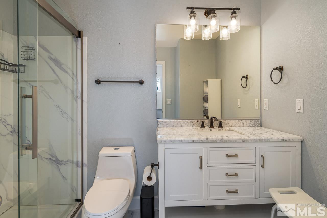 326 East 7th Street Reno, NV 89512 - Photo 6 of 21 a bathroom with a granite countertop sink toilet a mirror and shower