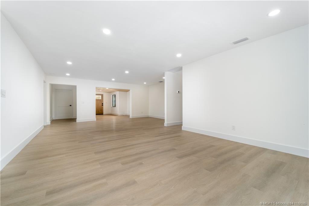 5549 Southeast Normandy Avenue Stuart, FL 34997 - Photo 5 of 21 an empty room with wooden floor and natural light