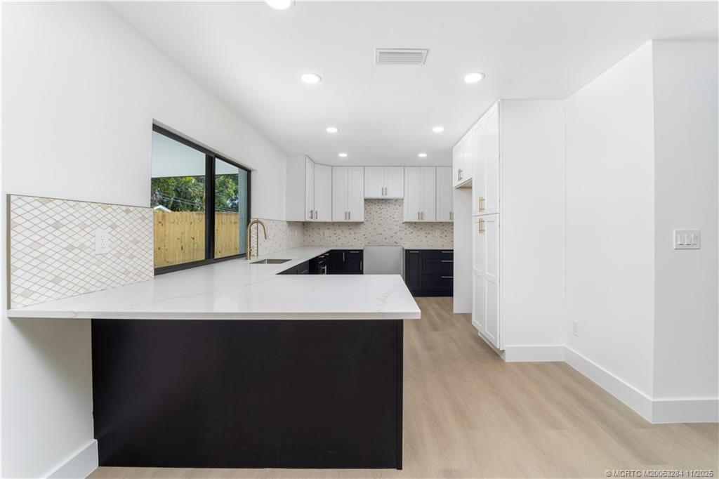 5549 Southeast Normandy Avenue Stuart, FL 34997 - Photo 7 of 21 a kitchen with stainless steel appliances a refrigerator sink and cabinets