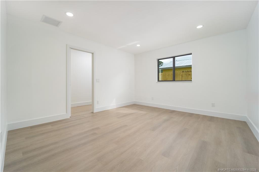 5549 Southeast Normandy Avenue Stuart, FL 34997 - Photo 10 of 21 an empty room with windows and painting on the wall