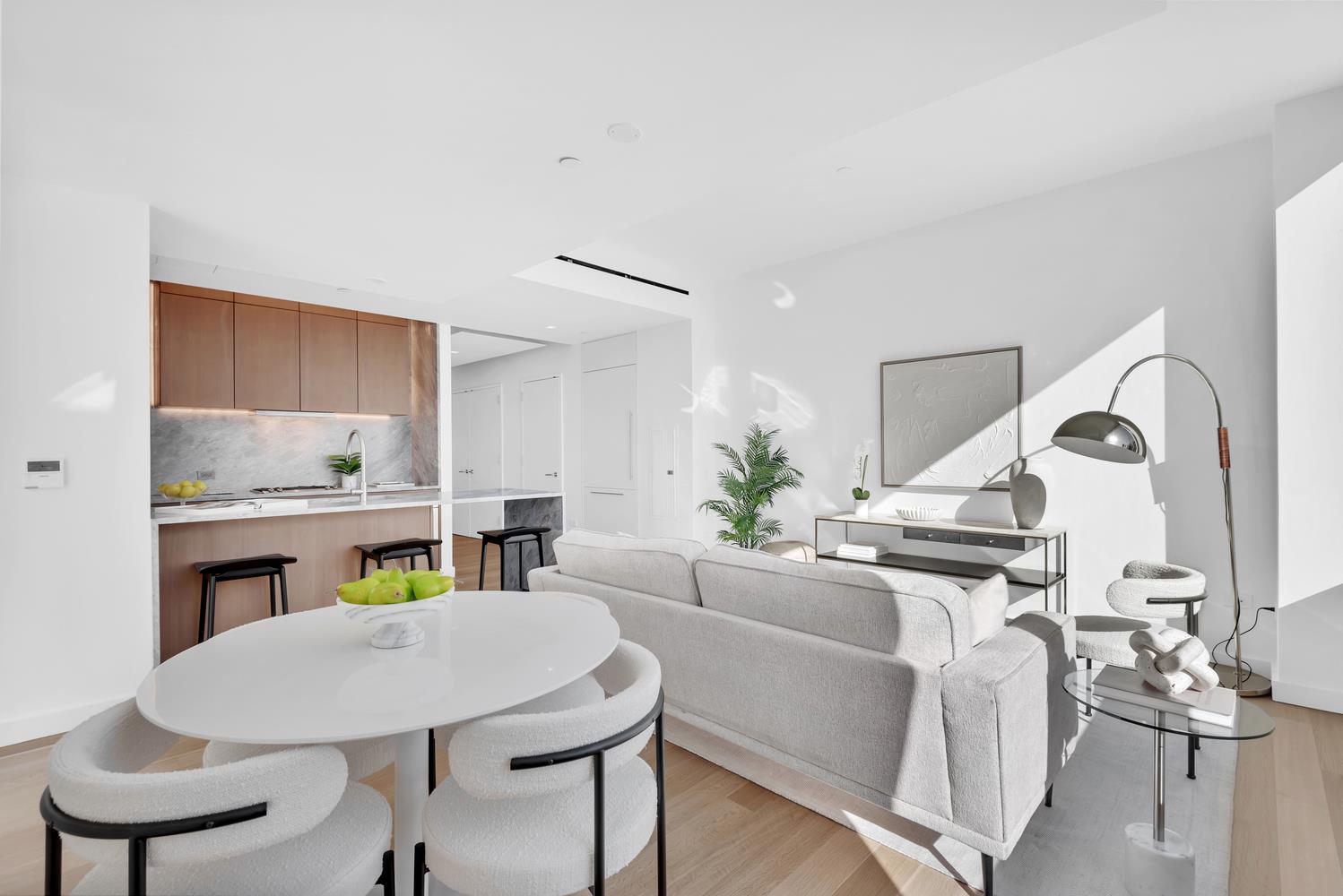 611 West 56th Street, Unit 3A Manhattan, NY 10019 - Photo 3 of 23 a kitchen with a table chairs and a living room